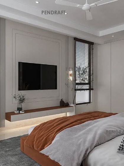 A view of the TV and lounge area in the same bedroom, showcasing a clean, minimalist design that allows the large windows and natural light to take center stage.