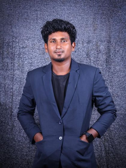 A confident pose for a men's studio portrait. With hands in pockets, the subject looks directly at the camera, projecting a relaxed yet professional image.