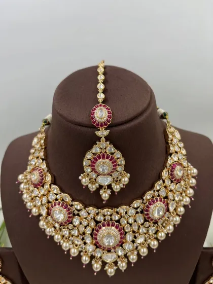 The full 'Zarista' set in ruby red, including the necklace, maang tikka, and earrings.
