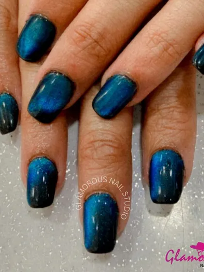 A deep and mesmerizing blue-green cat-eye effect on short, square nails for a simple yet striking look.