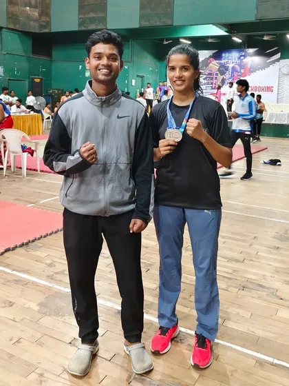 A moment of pride between coach and student. One of our athletes poses with her coach after winning two silver medals at the state-level championship, a result of their shared dedication.