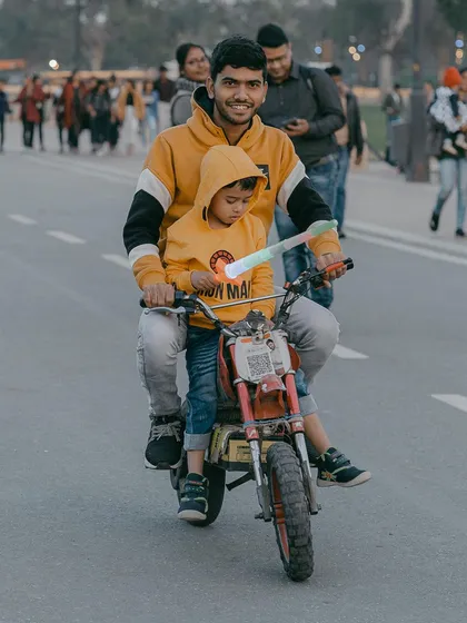 A heartwarming candid of a father and son enjoying a toy bike ride at India Gate. I love capturing these simple, joyful family moments that happen every day.