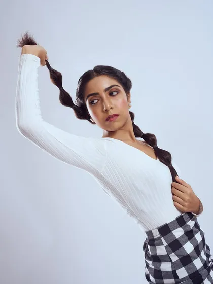 A cute and playful look featuring bubble braids and a gingham skirt. The makeup is kept fresh and pretty, with a soft wing and a hint of pink.