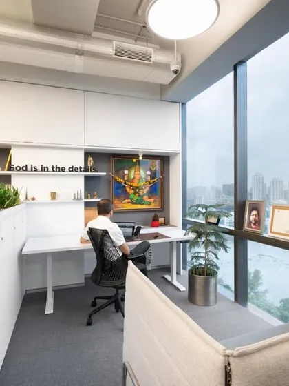 A bright and airy workstation with a view. Integrated planters create a natural partition, and the design maximizes natural light from the floor-to-ceiling windows.