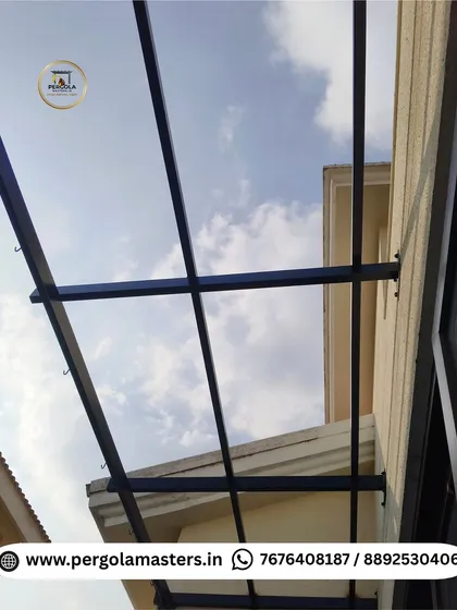 The bare metal frame of a pergola being installed against a building's wall. This image shows the strong structural connections and the initial phase of our professional installation process.