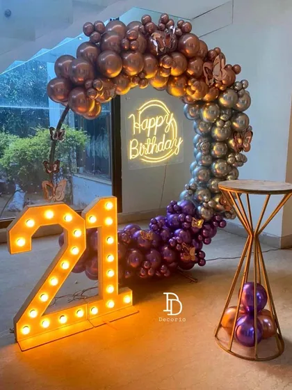 Another angle of the stylish 21st birthday ring setup, showing the interplay of metallic balloons, the glowing marquee numbers, and the neon sign.