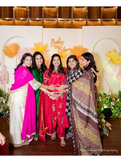 The mom-to-be surrounded by friends and family in front of the "Baby in Bloom" backdrop. Our decor creates the perfect setting for these cherished photo moments.