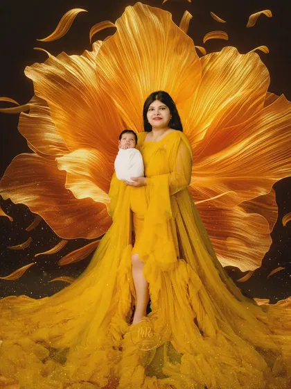 A mother holds her newborn, enveloped in a stunning yellow gown that resembles a giant flower.