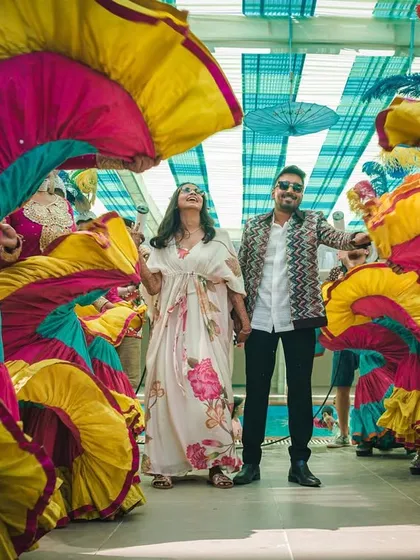 Another angle of the vibrant carnival entry, showcasing the colorful swirling skirts of the dancers that create a tunnel of color for the couple.