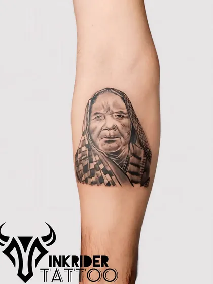 A beautiful portrait of a grandmother, capturing her kind expression in detailed black and grey. We take great pride in creating realistic memorial portraits.