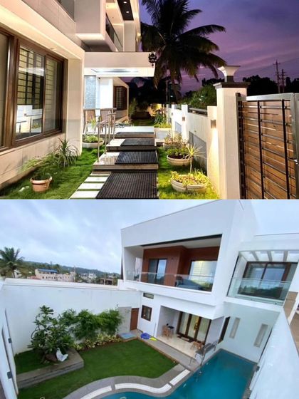 The home's design includes multiple landscaped areas and a pathway that leads from the gate to the entrance, creating a journey through greenery.