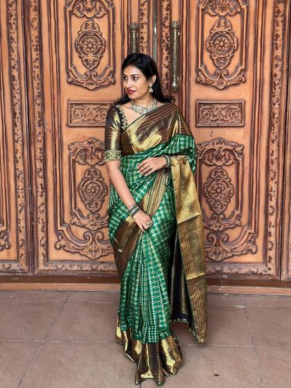 Our client Chitra Reddy looks splendid in this rich green checkered Kanchipuram silk saree with a wide gold border.