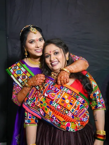 A fun and happy moment between two clients. Their makeup is fresh and festive, perfect for a night of dancing.