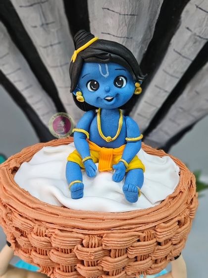 A close-up of the adorable baby Krishna figurine from our Janmashtami anti-gravity cake.