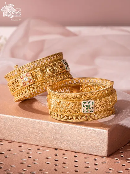 The Svarn Meenakari Kada is a fortress of artistry for the wrist. Crafted in 22ct gold, its surface is a canvas for vibrant, hand-painted Meenakari enamel work, showcasing a centuries-old technique in a bold, modern form.