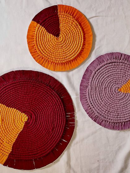 A set of three color-blocked macrame mats in rich tones of maroon, mustard, and lavender. Arranged together, they create a beautiful composition, showcasing how different colors can work together in a custom set.