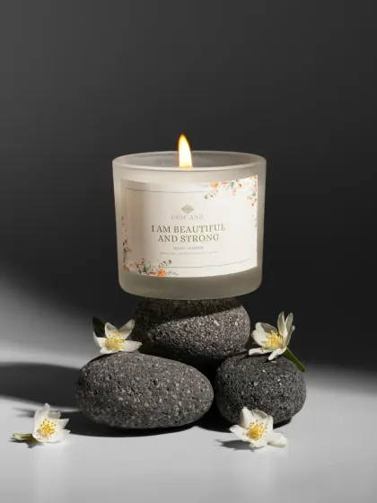 A candle balanced on a stack of dark stones, creating a zen-like, minimalist scene. This conceptual shot is great for brands with a focus on wellness and tranquility.