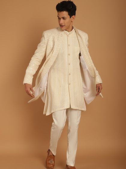 An ivory Indo-Western outfit with a long, flowing jacket, showcasing a breezy and elegant look. The subtle sparkle in the fabric catches the light beautifully.