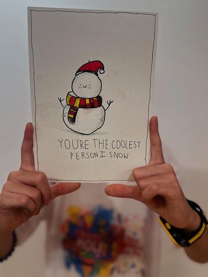 "You're the coolest person I snow." A student holds up his clever and charming snowman card, perfect for the holiday season.