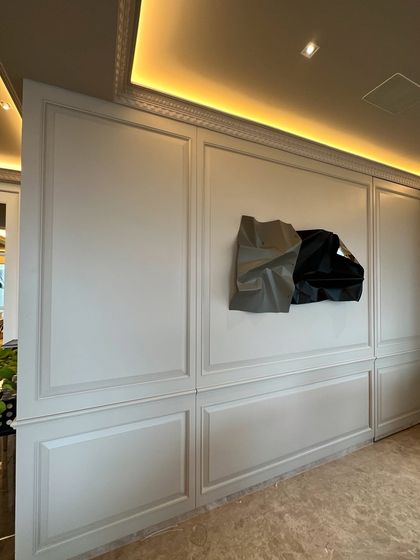 The sculpture seems to float on the beautifully crafted wall.