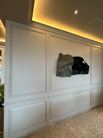 The sculpture seems to float on the beautifully crafted wall.