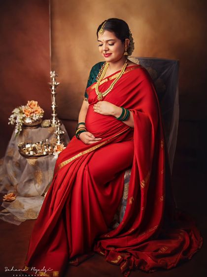 A quiet moment of reflection. This portrait captures the serene beauty of motherhood, with traditional elements like the brass lamp adding a spiritual and classic touch to the scene.