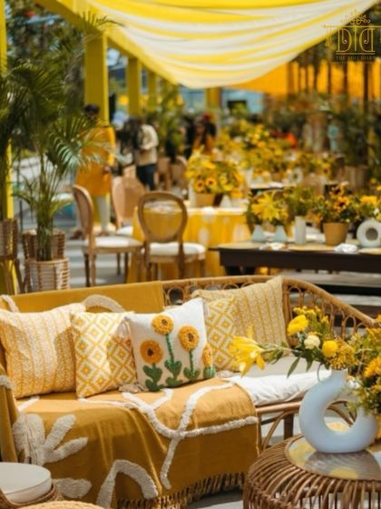 A cozy and chic Haldi lounge area with a sunny yellow theme. The sunflower-embroidered pillows and comfortable throws make it an inviting spot for guests to relax and enjoy the festivities.