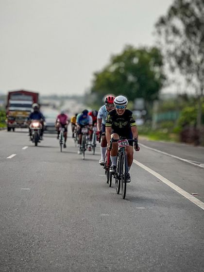The peloton, a colorful and dynamic sight, races down the highway.