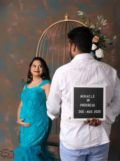 A playful secret. The "Miracle in Progress" sign held behind his back adds a fun and creative twist to this lovely couple's portrait.