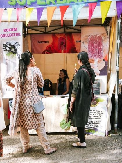 A visitor enjoying a handmade popsicle from a food stall. Our markets offer a variety of artisanal and homemade foods to delight your taste buds.