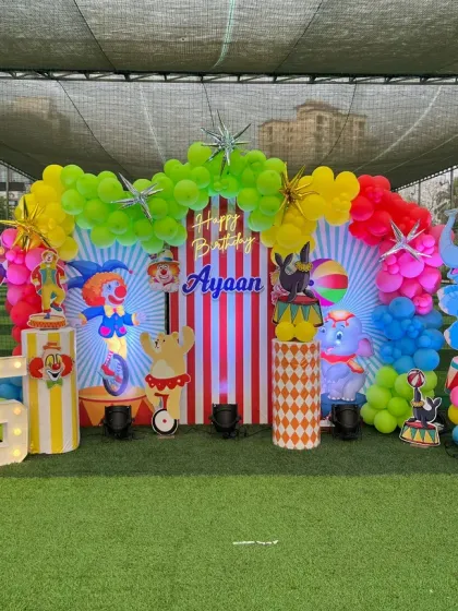 We created a full-scale carnival theme for this outdoor 5th birthday party. The setup includes a vibrant balloon arch, life-sized cutouts of circus animals and clowns, and custom-striped pedestals for a truly immersive experience.