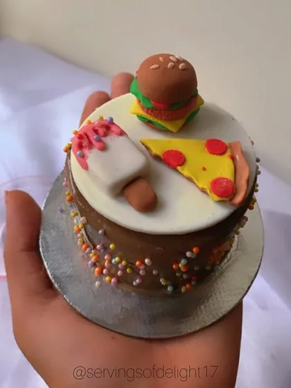 Mini cake calories don't count, right? This fun-sized cake is topped with adorable, handmade fondant miniatures of a burger, pizza, and ice cream.