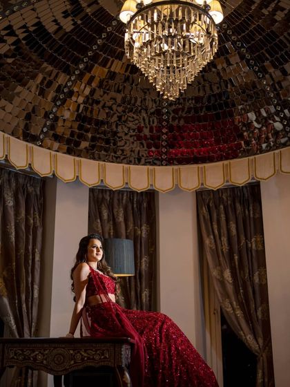 A glamorous bridal portrait in a luxurious suite. We use the opulent surroundings and dramatic lighting to create a high-fashion look.