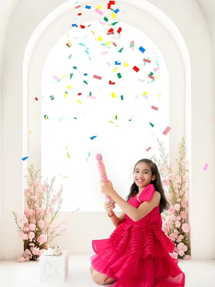 Pure birthday joy. This shot captures the excitement of an older child's celebration with a burst of colorful confetti against a bright, clean backdrop.