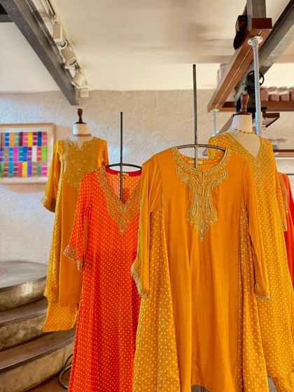 A display of flowy, festive silhouettes by Sheetal Batra in vibrant shades of orange and yellow, perfect for easy, breezy celebrations.