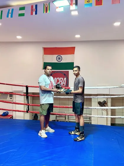 Recognizing our best-performing students by gifting them customized boxing shoes. This is our way of motivating them.