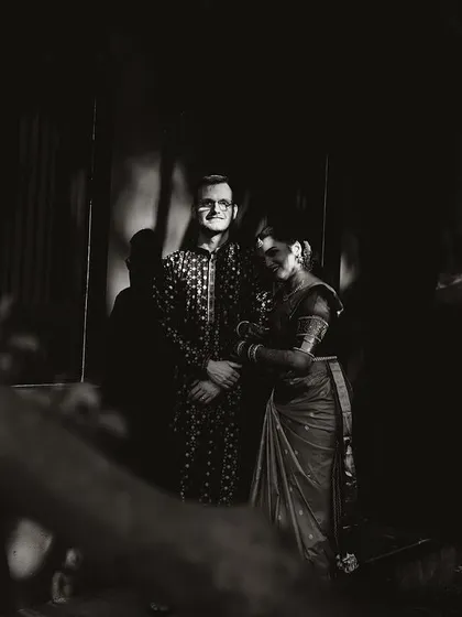A dramatic black and white portrait of a couple, the shadows and light creating a mysterious and romantic mood.