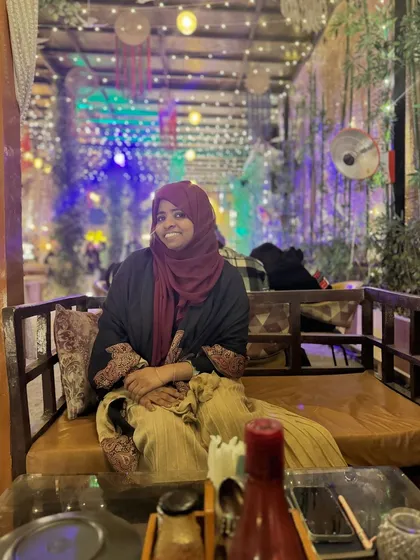 A photo of me at a cafe, a moment of peace. My art has given me the freedom to enjoy these small moments, and I want the same for you.