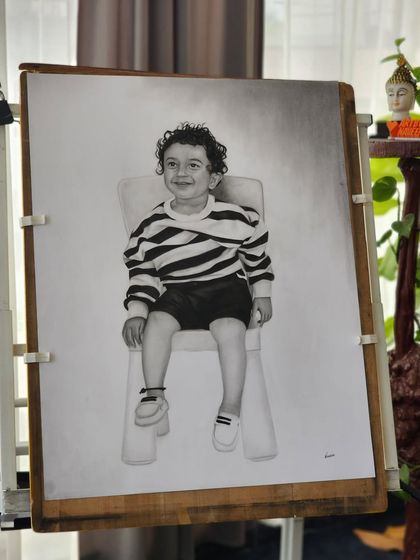 The full A1 size portrait on my drawing board, showing the completed figure of the boy sitting on a chair.
