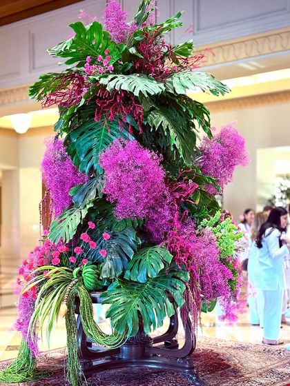 The sheer abundance of pink and green florals creates a sense of luxurious escape. This installation is a testament to the power of color and foliage to create a distinct mood.