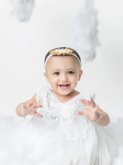 A happy little angel sitting amongst the clouds. The all-white theme is so pure and beautiful.