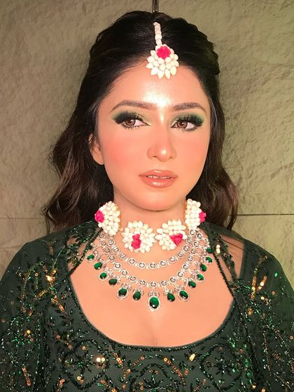 A confident portrait of the Mehendi look. The makeup is designed to be bright and photogenic, perfect for daytime celebrations.