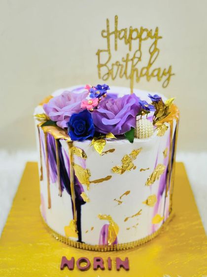 A different angle of the artistic purple floral cake, highlighting the gold leaf details.