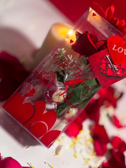 For Rose Day, I offer this cute gift box that combines a rose with my handmade chocolates. It's a classic combination presented in a clear box decorated with hearts.