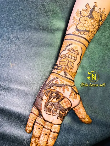 The final look of a bridal hand design featuring a majestic elephant on the palm and a peacock on the arm. I teach how to combine different motifs to create a cohesive story.