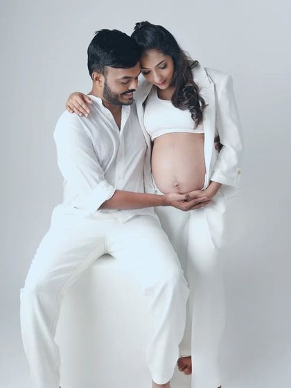 A tender moment where both partners cradle the baby bump. This pose is a beautiful visual representation of their shared love and anticipation for their little one.