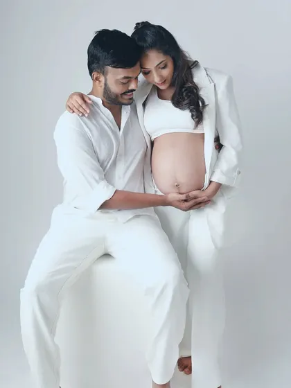A tender moment where both partners cradle the baby bump. This pose is a beautiful visual representation of their shared love and anticipation for their little one.