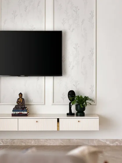 This TV unit combines a muted floral wallpaper with classic wall beading and a floating console with grooved drawers, creating a look that is both practical and visually stunning.