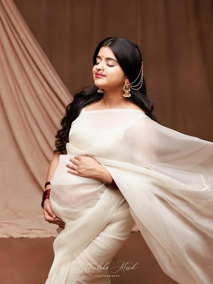 A moment of pure joy and grace in a flowing white saree. The soft fabric and happy expression create a portrait that is both elegant and full of life.