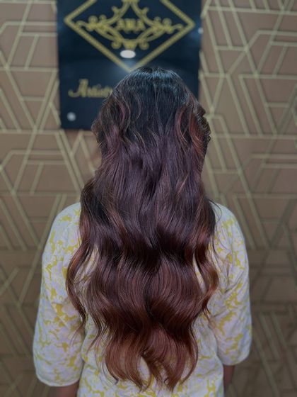 The glossy, dimensional waves in this photo are the result of a carefully crafted balayage. The color enhances the client's natural hair, giving it a glamorous finish.
